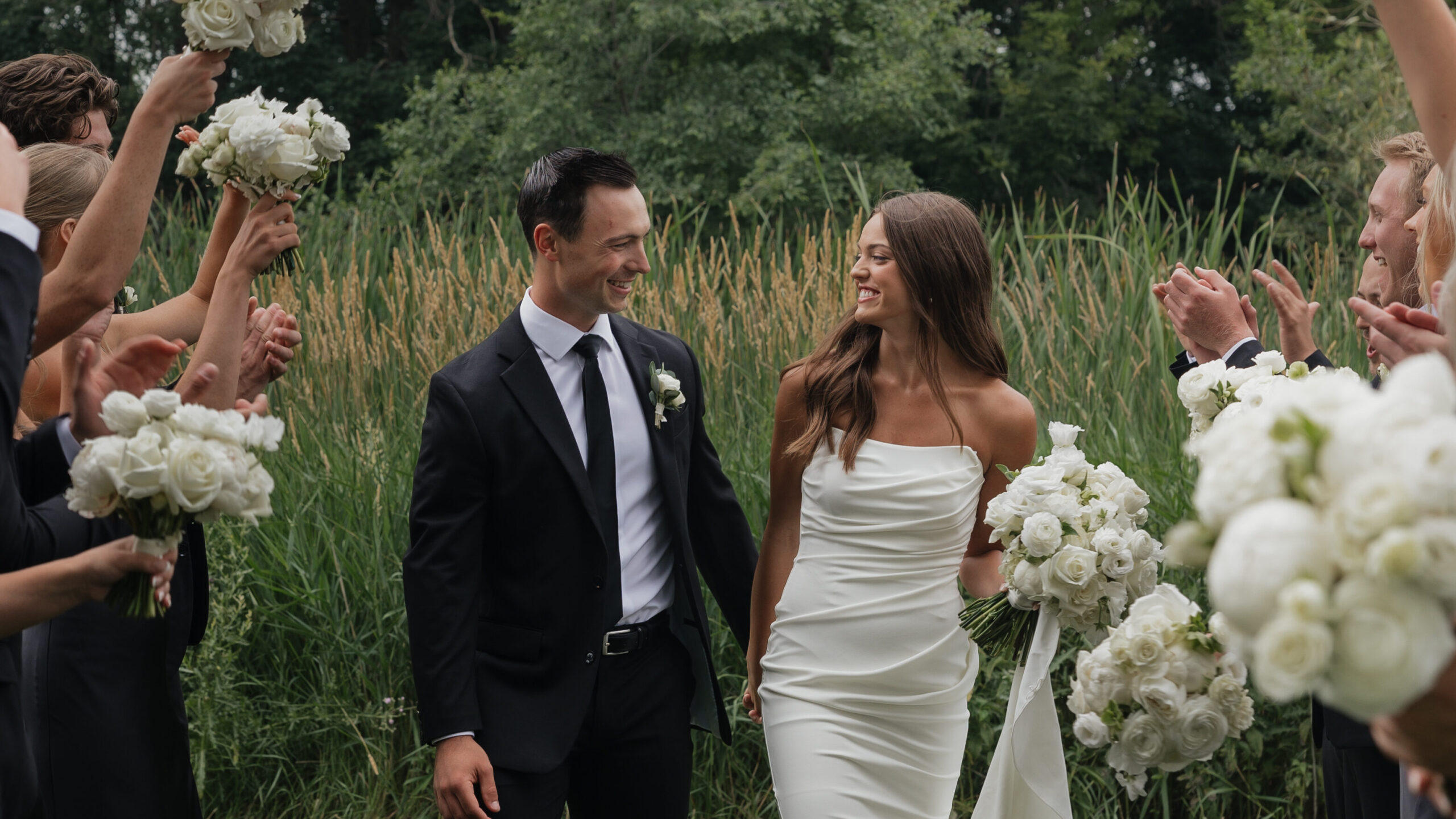 Bride and groom walking hand in hand through wedding party after ceremony, emotion-filled documentary wedding photography in Fargo ND