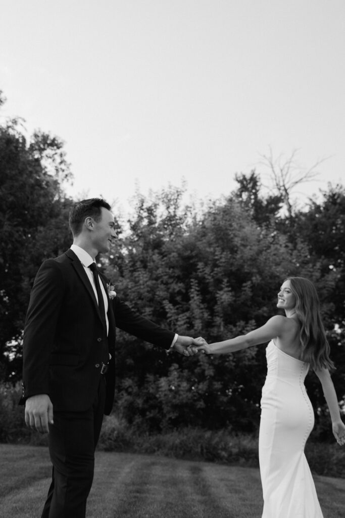 Bride and groom laughing and spinning together during portraits, documentary wedding photography in Fargo ND