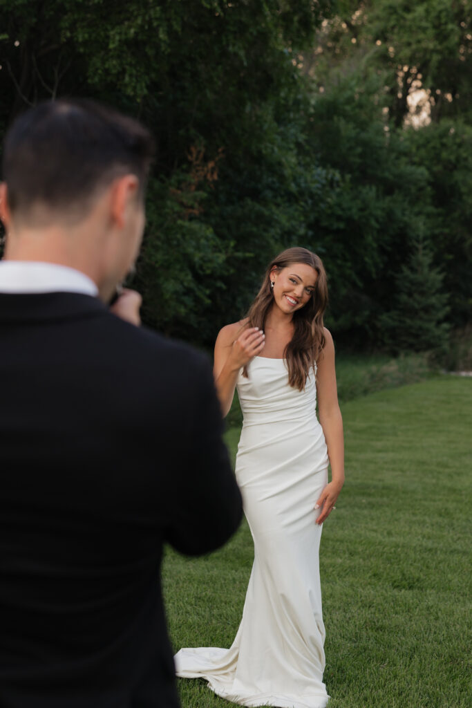 Photographer capturing bride smiling naturally during wedding portraits, documentary style wedding photography in Fargo ND
