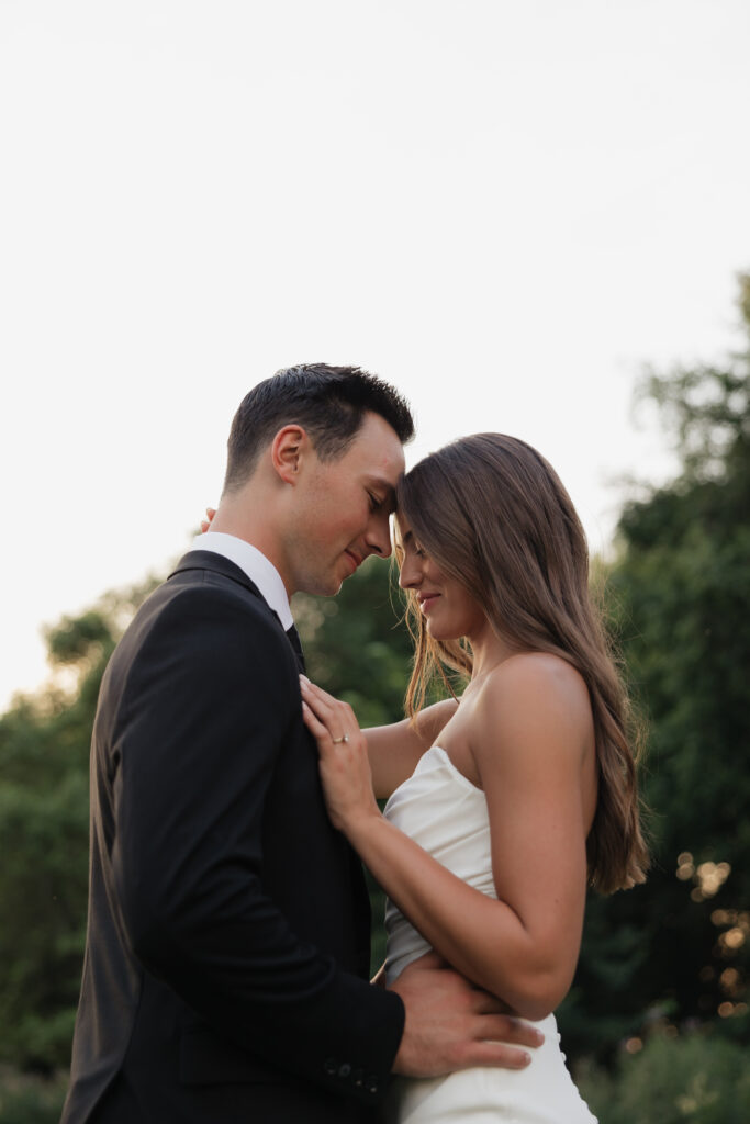 Bride and groom embracing during golden hour wedding portraits, emotion-filled wedding photography in Fargo ND