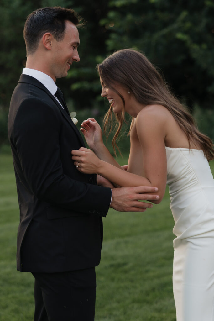 Bride laughing while groom holds her during candid wedding portrait session in Fargo ND