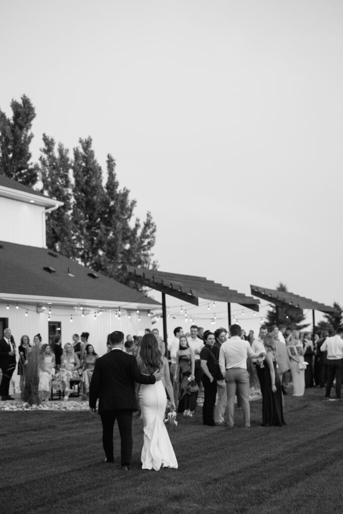 Wide documentary wedding reception photo with guests mingling outdoors, Fargo ND wedding photography