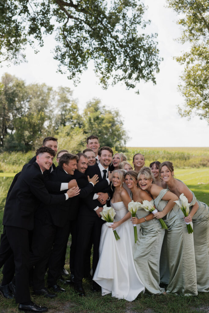 Wedding party | group hugging and laughing with bride and groom | outdoor wedding portraits