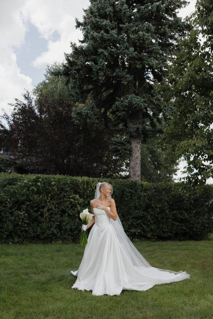 Bride | standing in strapless wedding gown holding bouquet | at a fargo nd wedding venue